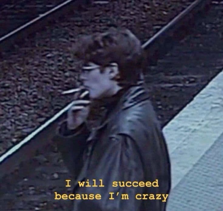 Grainy CCTV shot of a man smoking on a train platform, captioned 'I will succeed because I'm crazy'